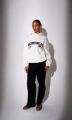 Model wearing a cream hoodie with 'Montreal' graphic text - front view on plain background