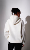 Model wearing a cream oversized  hoodie  - back view on plain background